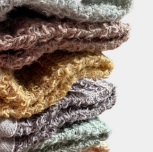 Stack of colorful textured towels on a pink background