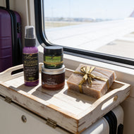 Adiva Naturals personal care products on a wooden tray with a window view on the go body care